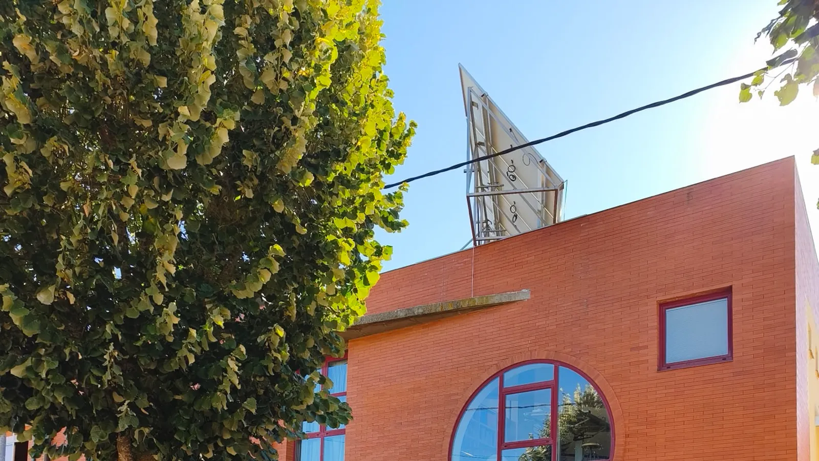 Fachada de ladrillo rojo del estudio de HDA arquitectos en Astorga, con su gran ventana circular